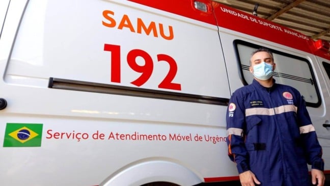 Socorrista encostado em ambulância do SAMU