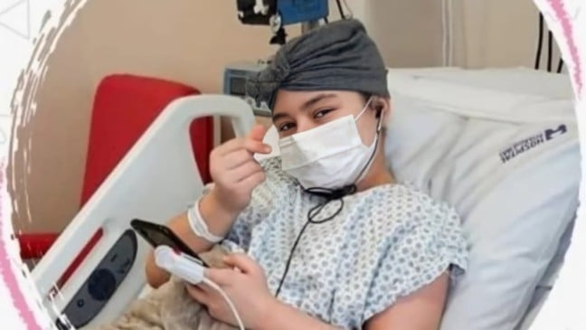 Menina deitada em cama de hospital