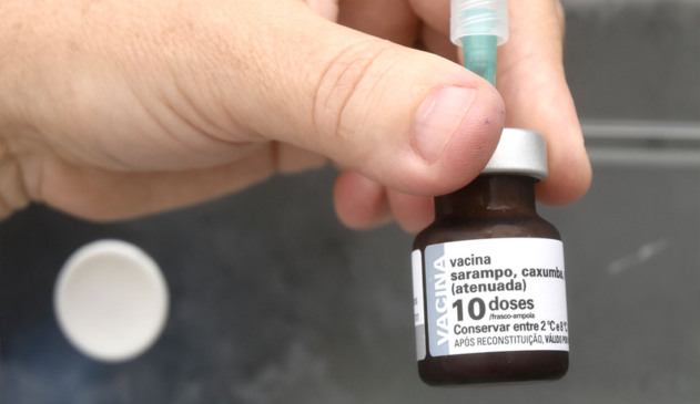 mão segurando dose de vacina do sarampo