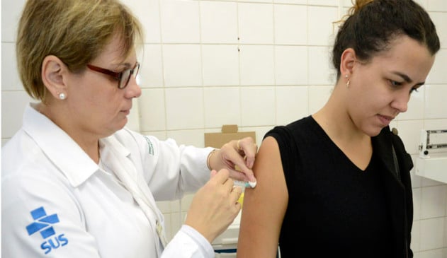 Enfermeira vacinando mulher adulta