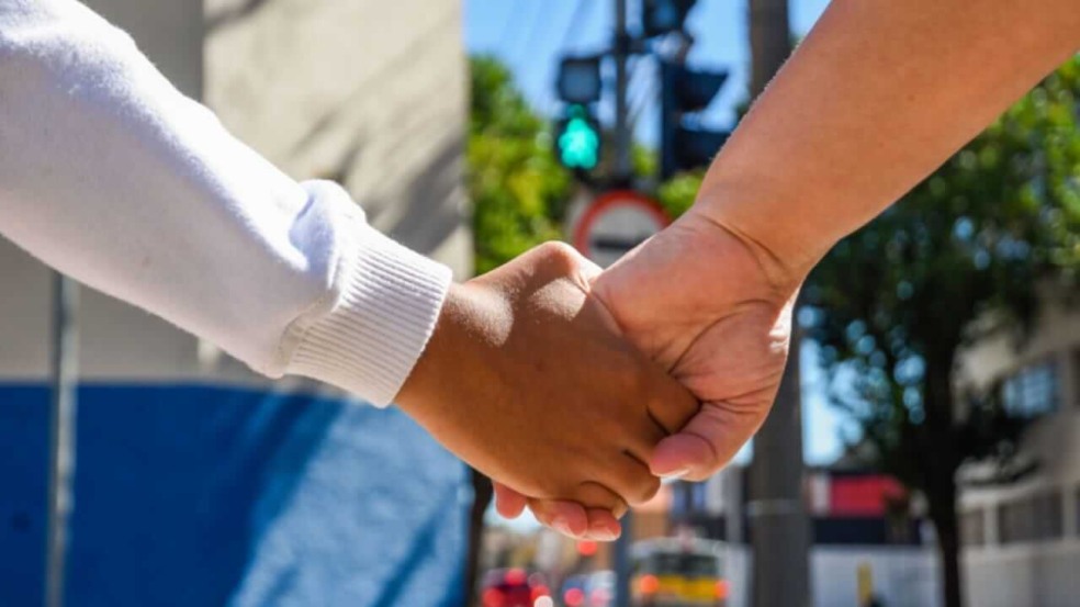 Criança e adulto de mãos dadas