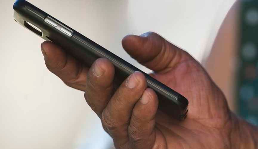 mão masculina segurando smartphone