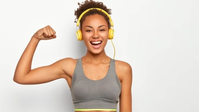 Mulher com fones de ouvido e roupa de academia