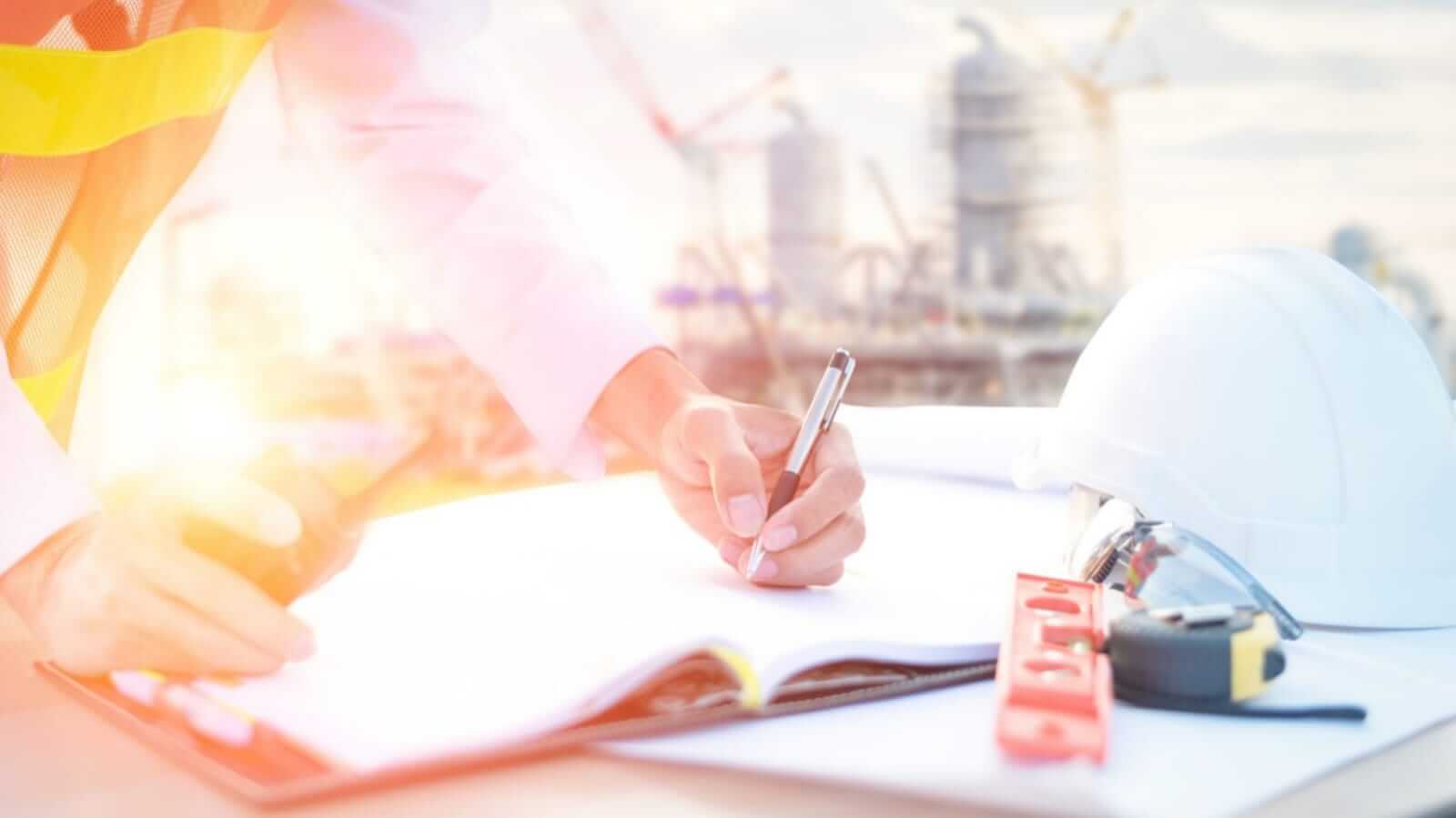 Engenheiro escrevendo em caderno