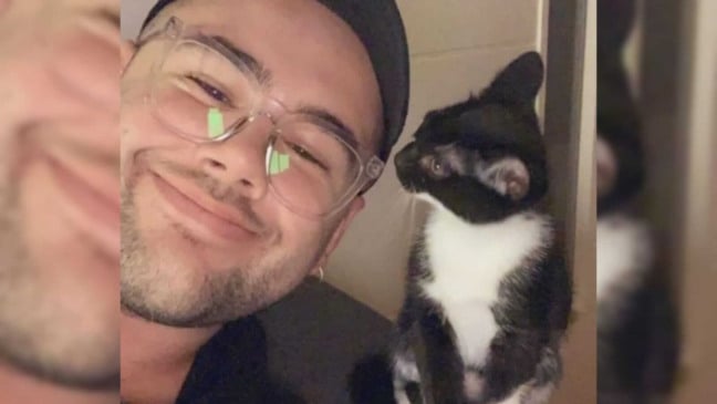 Homem e gato preto e branco no ombro