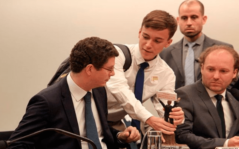 Jovem entregando o prêmio "Exterminador do Futuro" (Foto: @henriquemfernandes / Mídia NINJA)