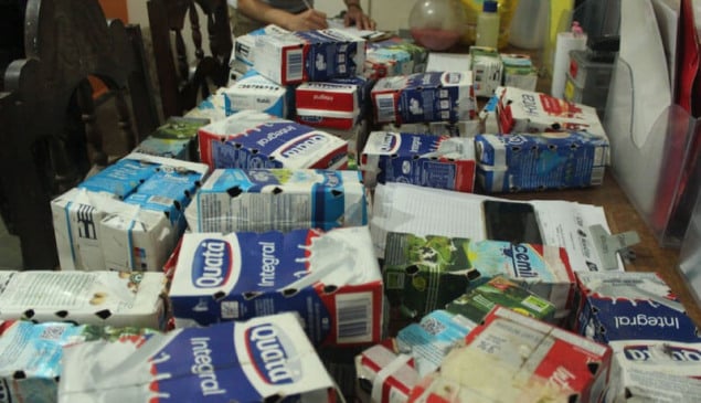 Caixas de leite com pequenos furos em cima de mesa