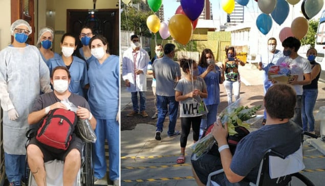 Médico sai de cadeira de rodas enquanto pessoas o esperam com balões do lado de fora