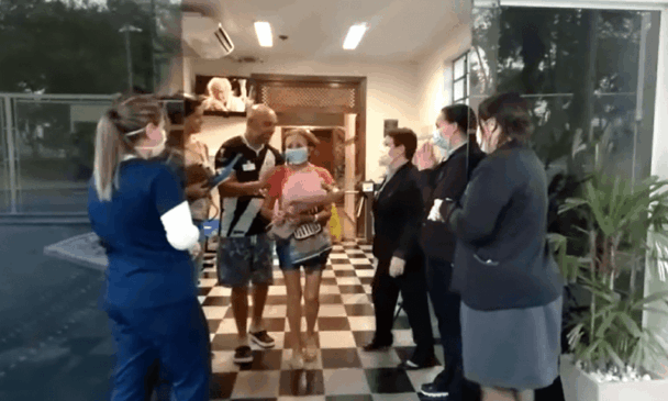 Paciente recebe buquê de flores na saída do hospital