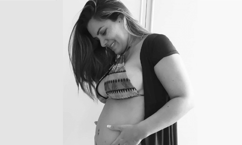 Mulher grávida segura barriga nas mãos Mulher grávida segura barriga nas mãos