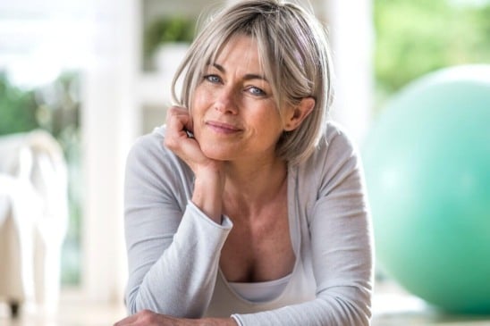 Mulher apoiada em mesa