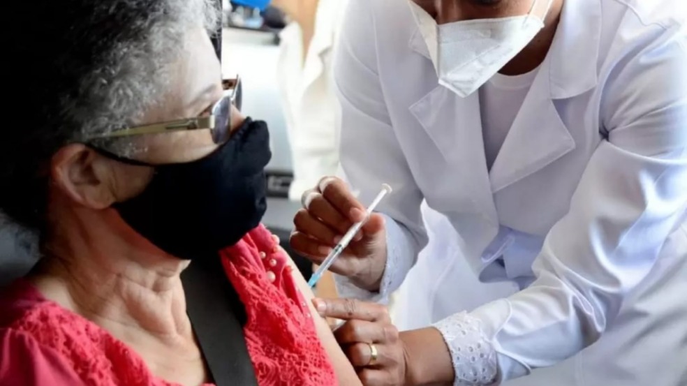 Idosa sendo vacinada em carro Idosa sendo vacinada em carro
