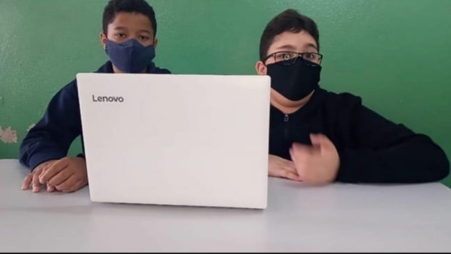 Alunos em mesa com computador