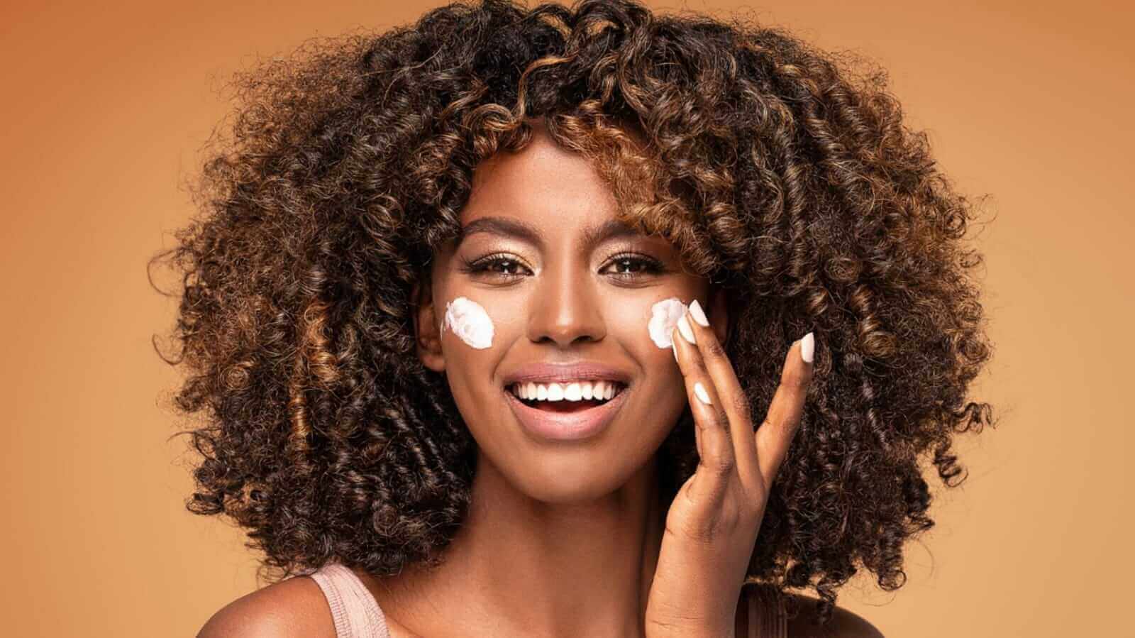 Mulher passando creme no rosto