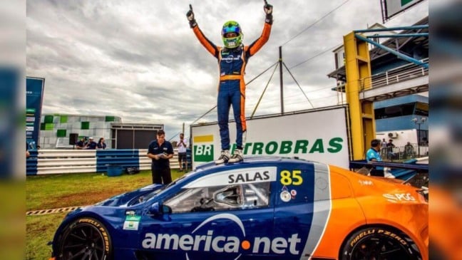 Guilherme em pé sobre o carro utilizado na prova