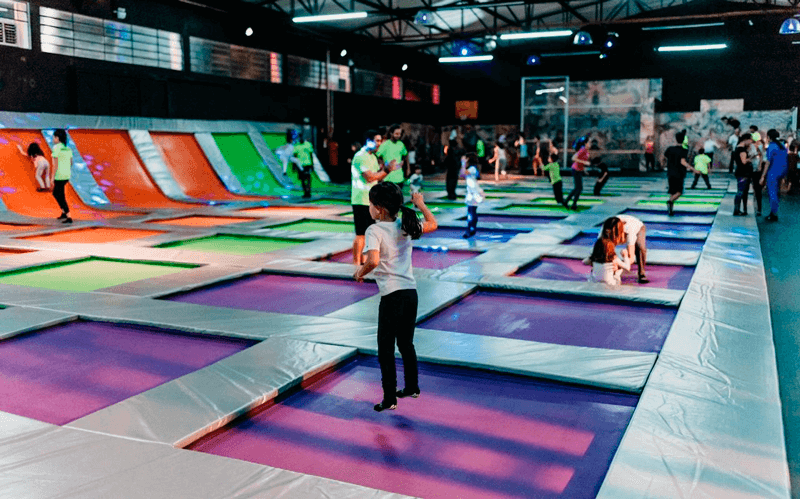 Crianças pulando no parque de trampolins Crianças pulando no parque de trampolins