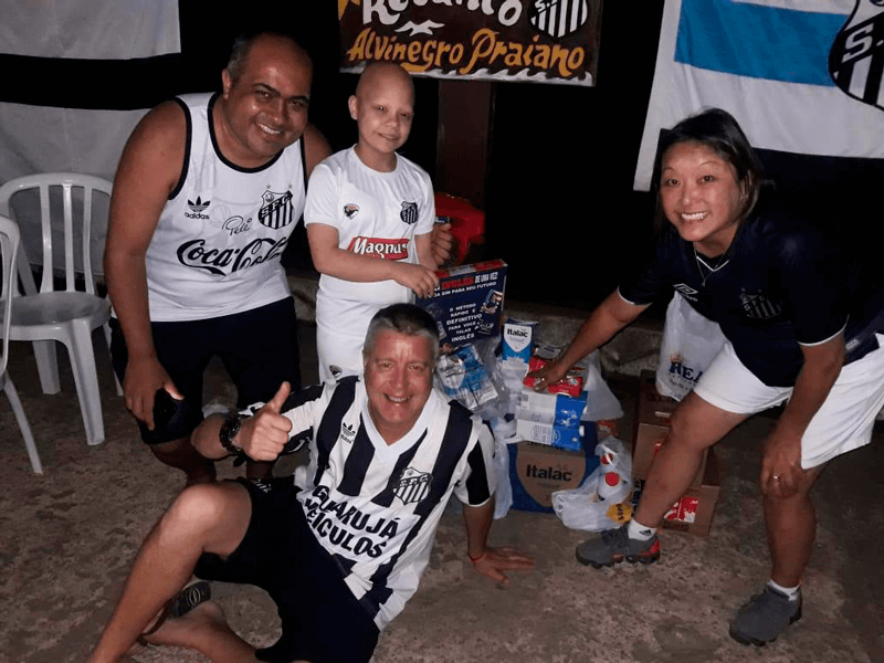 Membros do grupo santista ao lado das caixas de leite 