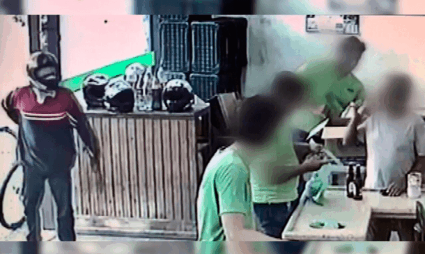 Criminoso na entrada do supermercado; funcionários olham para assaltante sem se importar