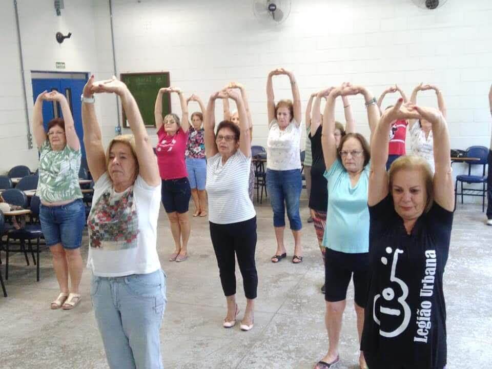 Mulheres fazem alongamento durante aula