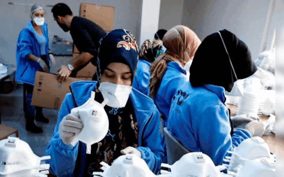 Colaboradores de empresa usam máscaras para trabalharem