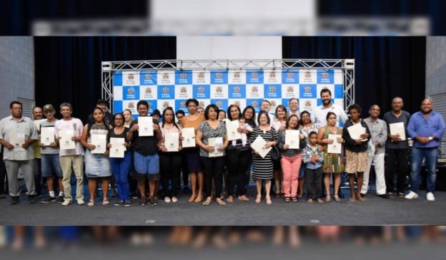 Moradores do Jardim Fepasa ao lado de autoridades segurando seus documentos de imóveis