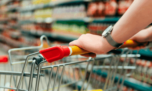 Consumidor segura barra de carrinho de supermercado