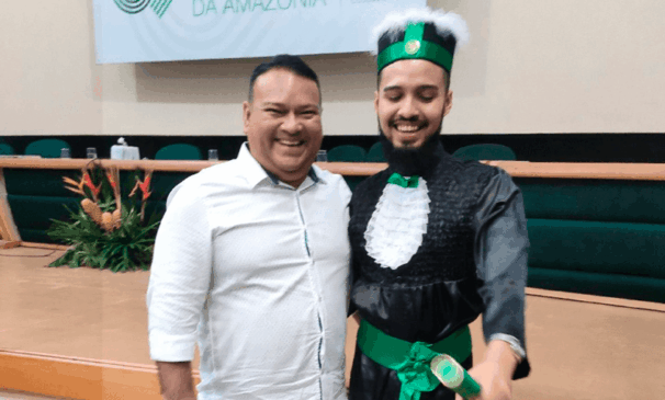 Elio se formando com o canudo na mão ao lado do pai