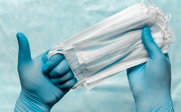 Mão com luva segura máscara cirúrgica
