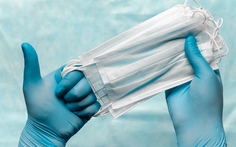 Mão com luva segura máscara cirúrgica