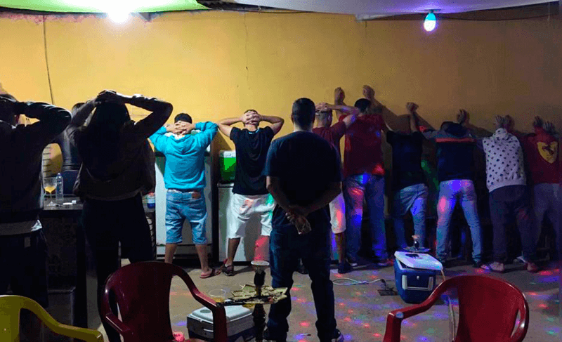 Convidados de frente para a parede com as mãos nas costas Convidados de frente para a parede com as mãos nas costas