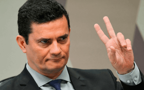 Moro faz gesto com dedos, como em "paz e amor"