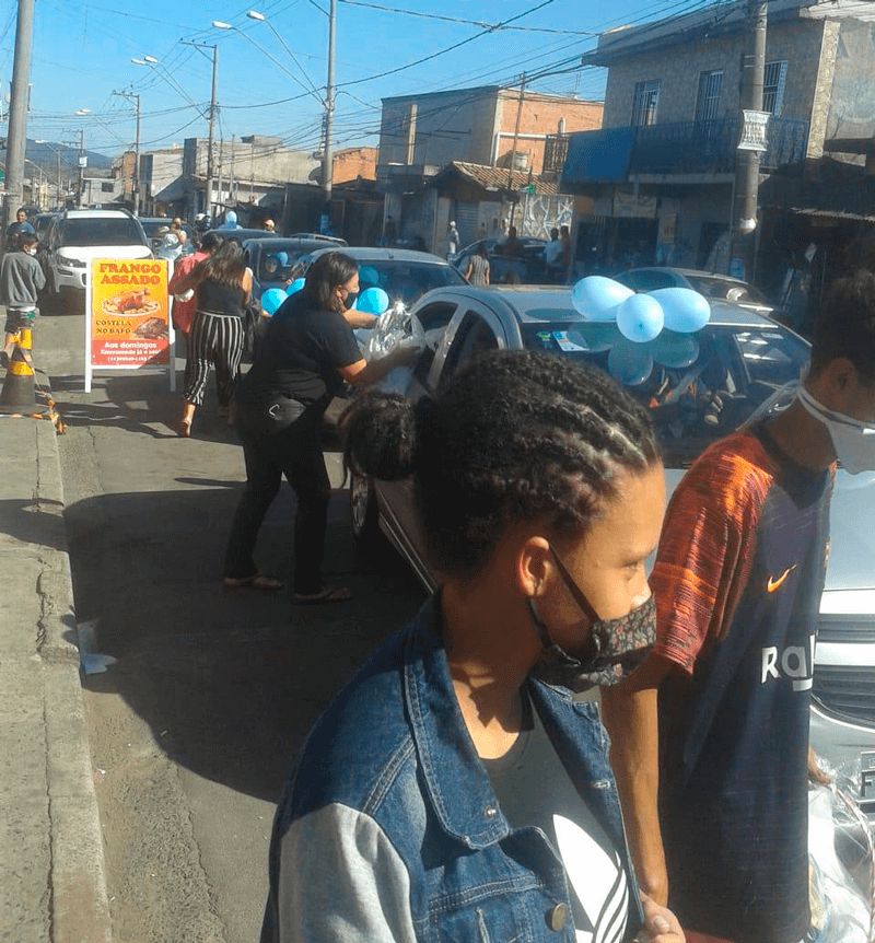 Pessoas pegam presentes das janelas dos carros