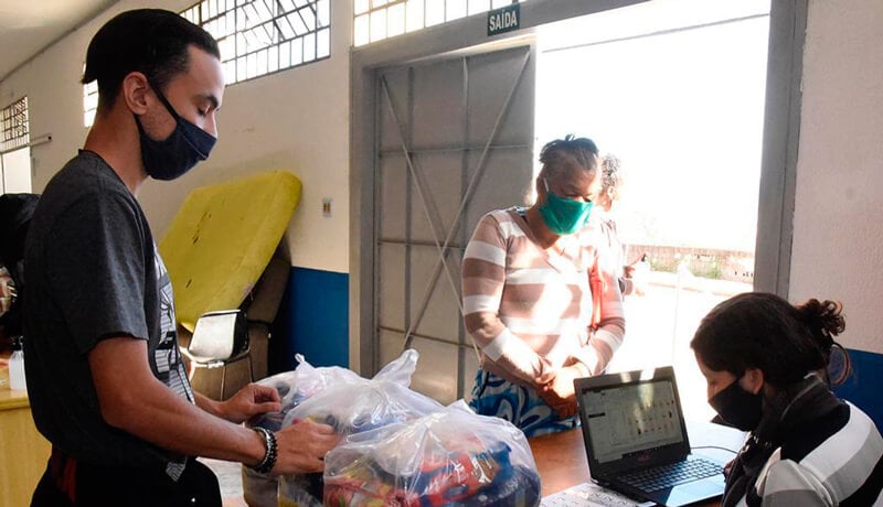 Família retira cartão pré-pago de auxílio em unidade de assistência social de Jundiai