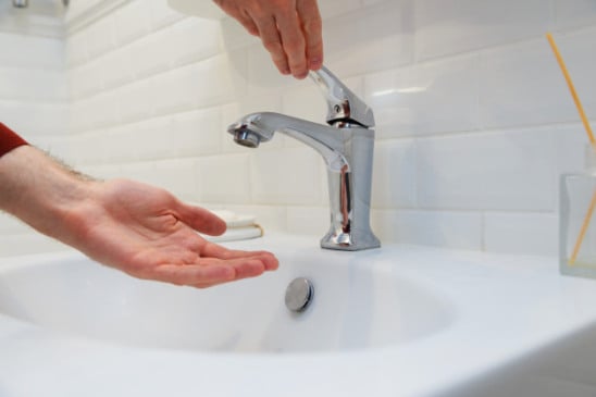 Pessoa abrindo torneira