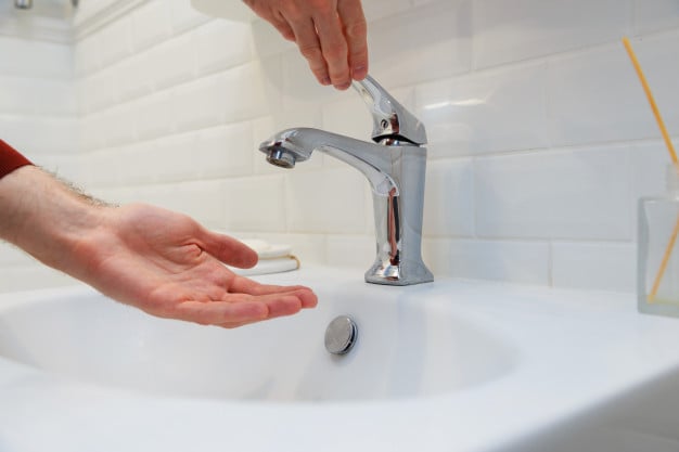 Pessoa abrindo torneira