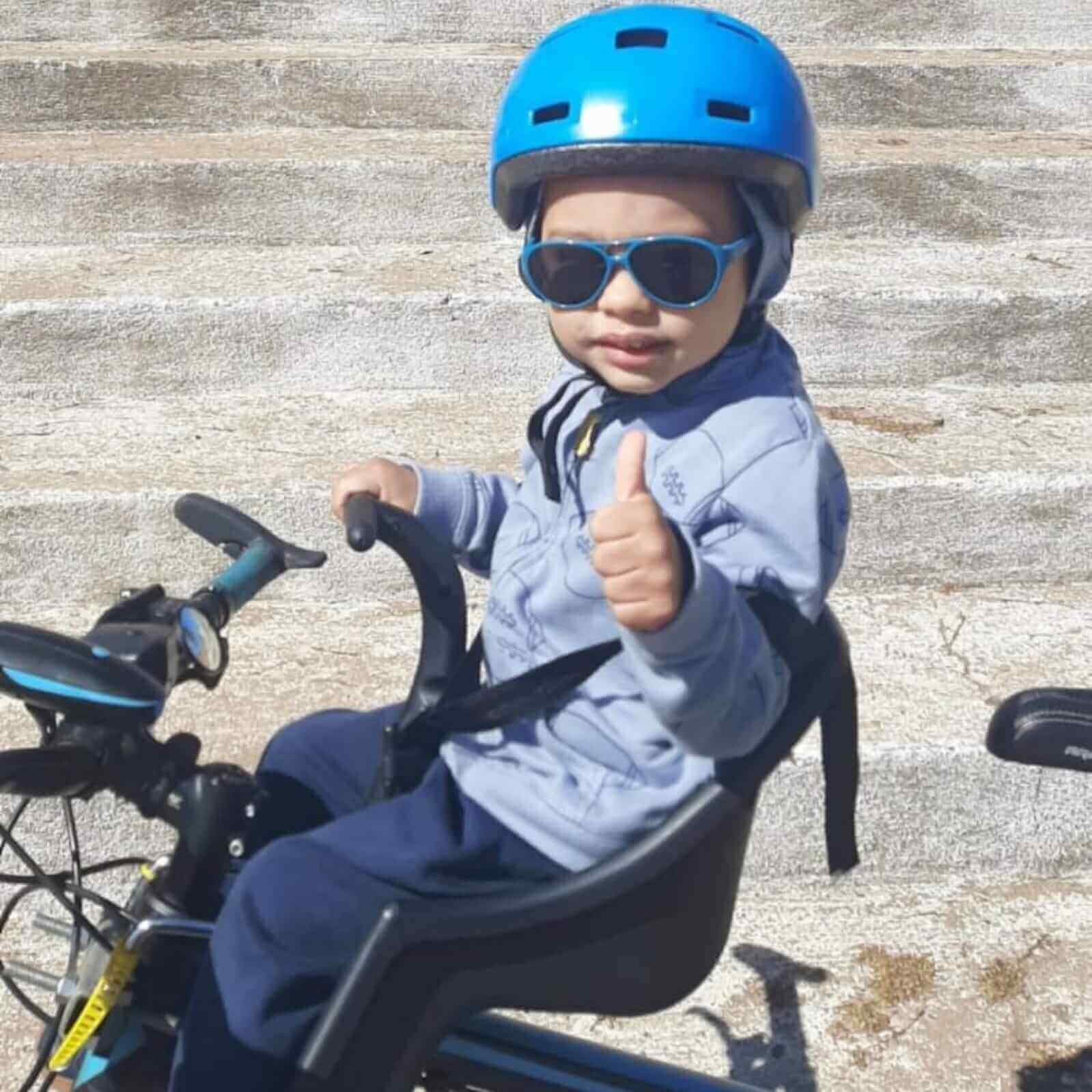 Criança em cadeirinha de bicicleta