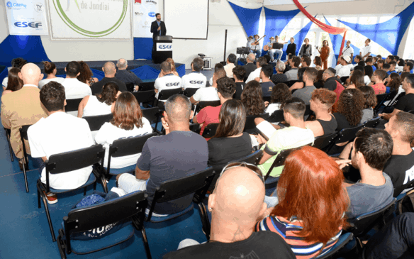Prefeito ao fundo fala aos presentes, na abertura do 14º Congresso da Esef.