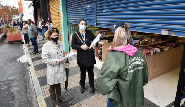 Equipe de fiscalização em frente a estabelecimentos comerciais