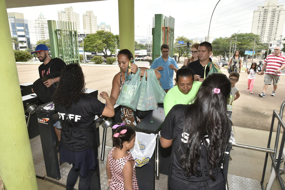 pessoas doando alimentos na entrada da festa da uva em jundiai