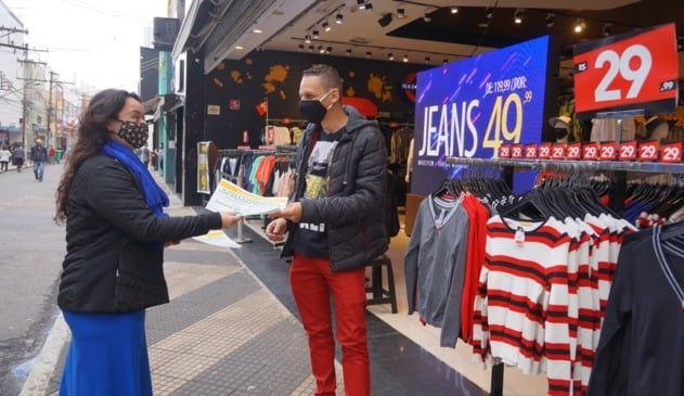 Foto de mulher entregando cartaz para vendedor