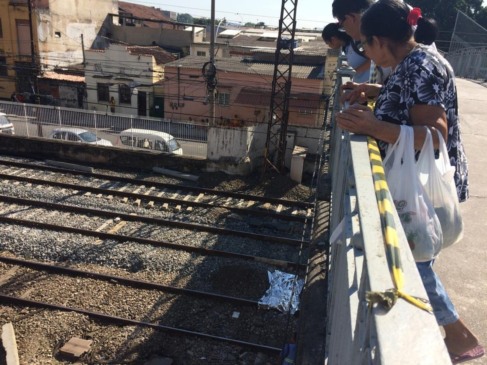 Pessoas observam corpo do jovem sobre a linha do trem próximo à estação Riachuelo, Zona Norte do Rio (Foto: Alba Valéria Mendonça/G1)