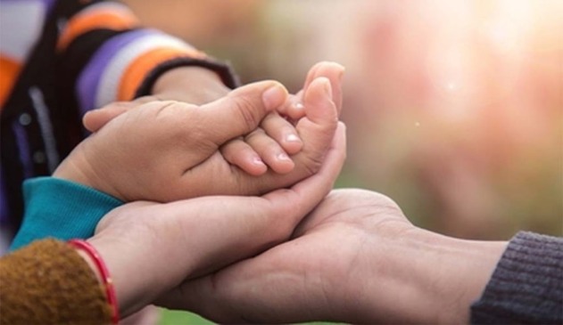 Pessoas segurando mãos de crianças