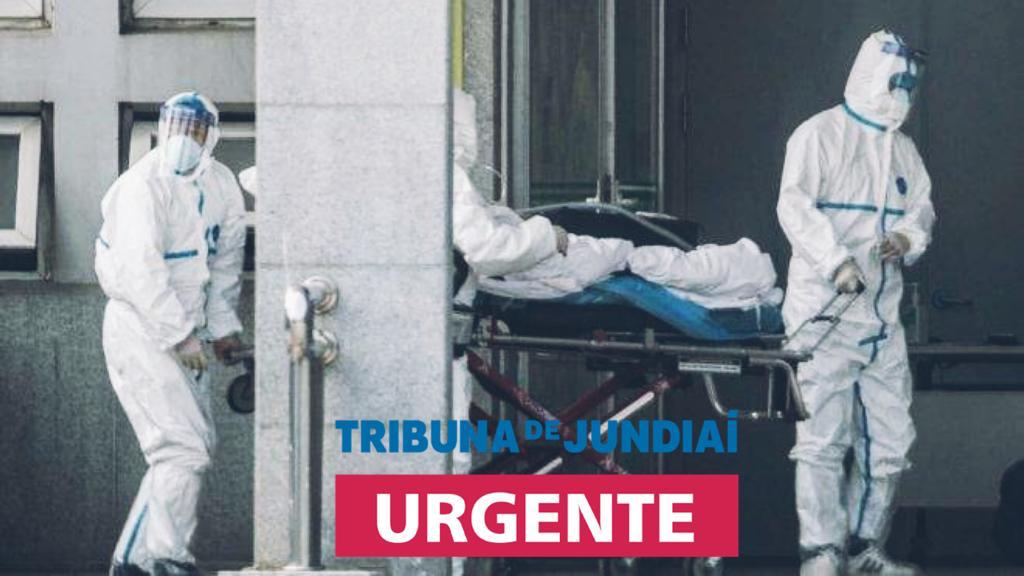 profissionais de saúde com máscara e equipamentos de proteção movem paciente com suspeita do vírus em maca