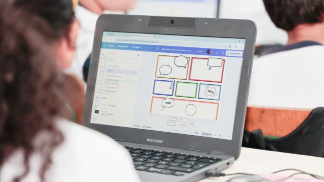 Criança utilizando computador em sala de aula.