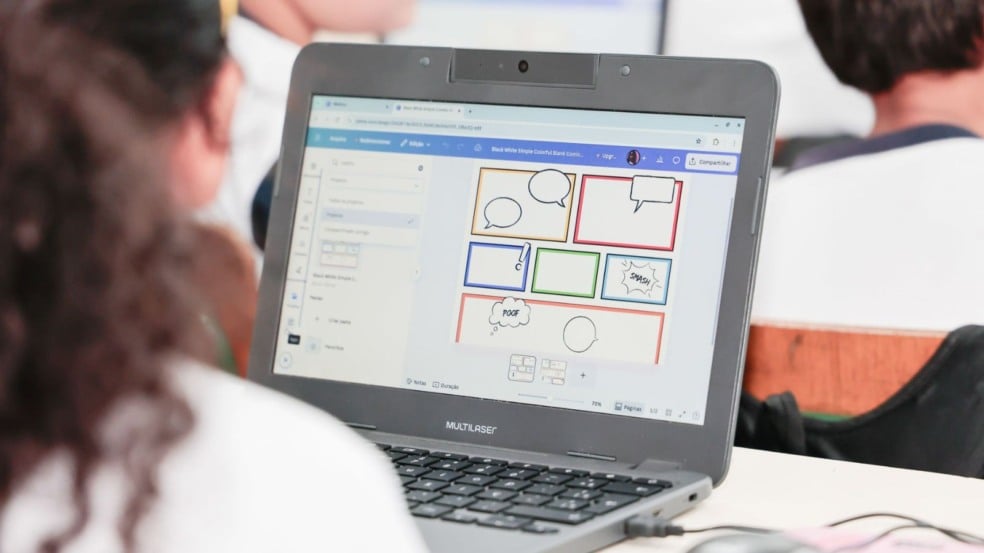 Criança utilizando computador em sala de aula.