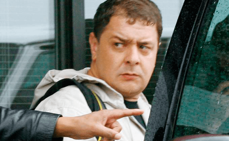 Fábio Luis Lula da Silva olhando para trás, enquanto entra em carro