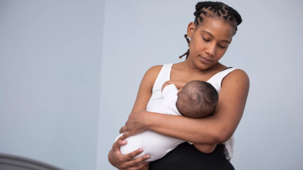 Mulher amamentando criança.