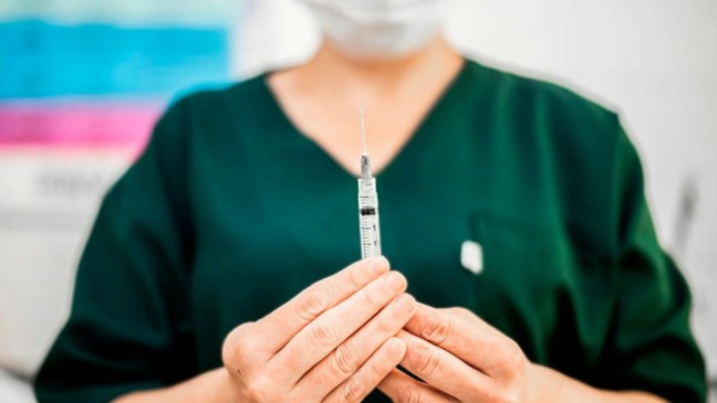 Profissional da saúde manuseando seringa de vacina