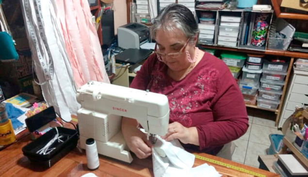 Artesã costura máscara em máquina de costura