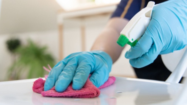 Mulher limpando balcão.